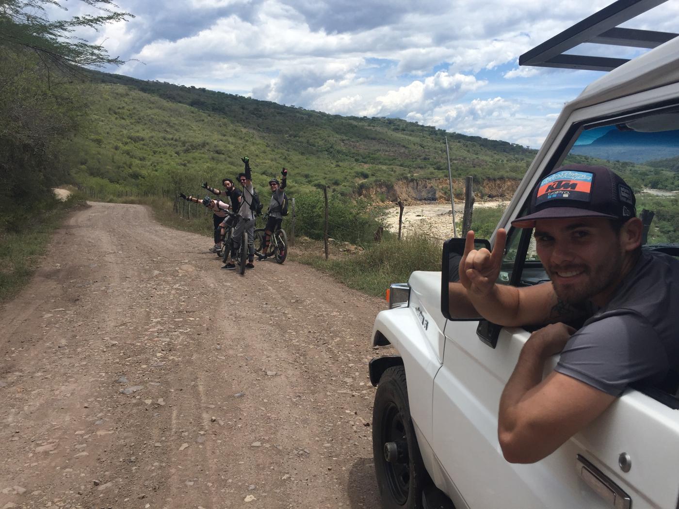 El guía en la camioneta y el grupo en bici